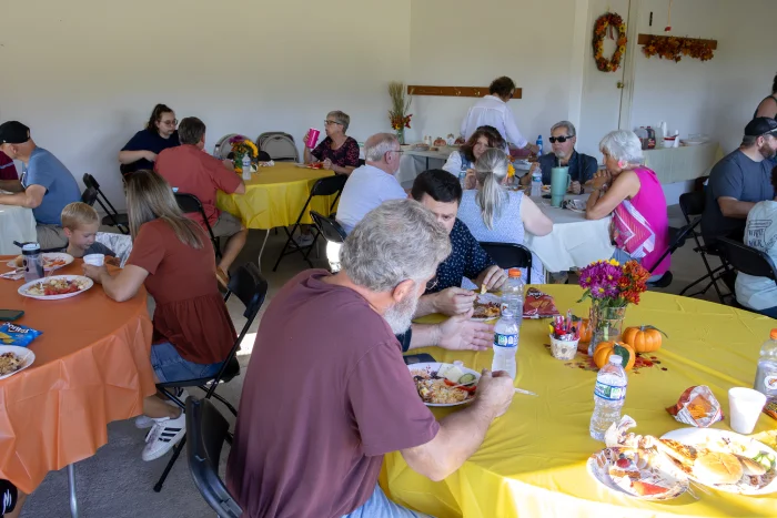 Numerous people eating a meal together at the last Fall Festival.